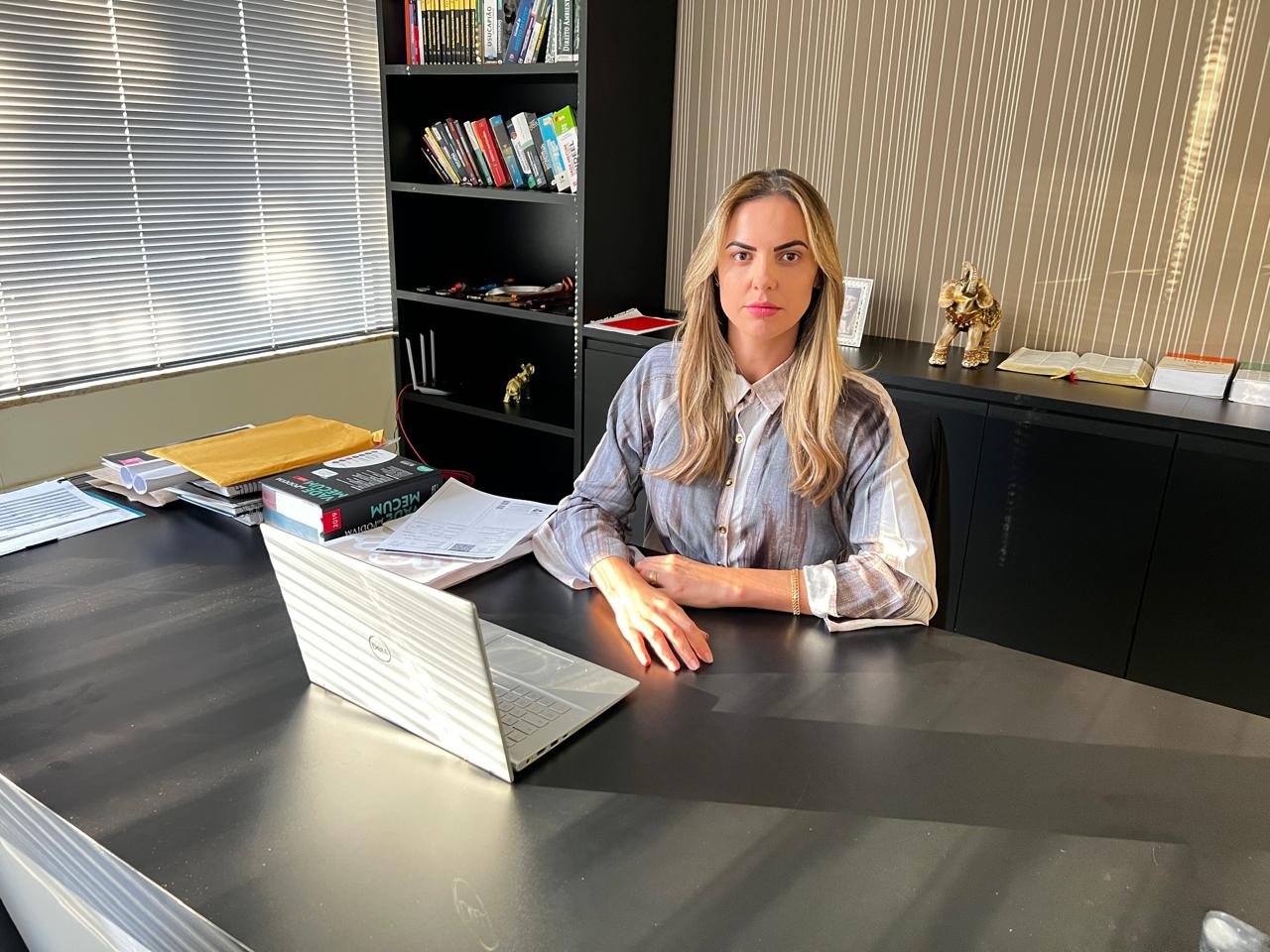 Karen Rocha sentada à mesa de seu escritório